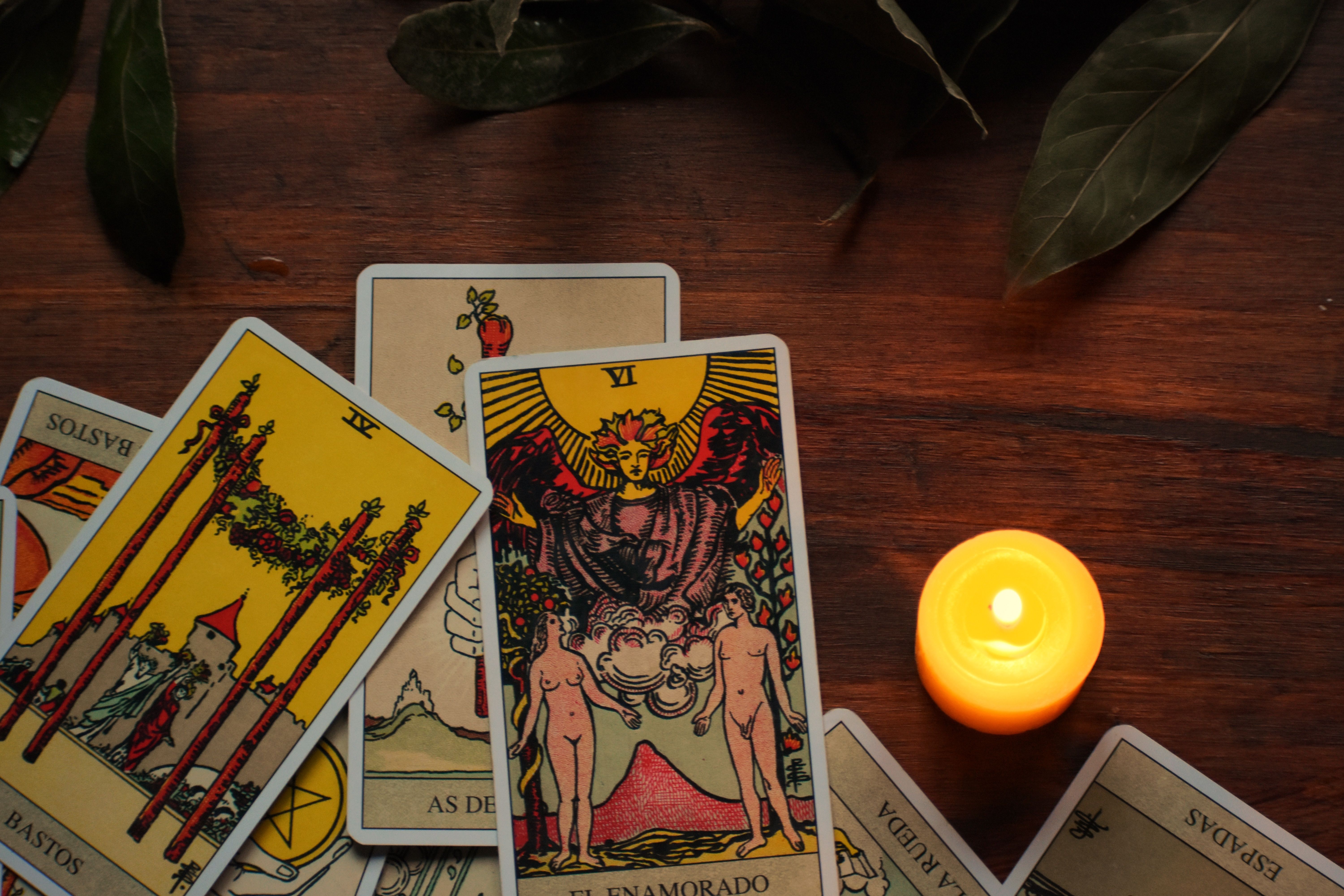 Tarot-Karten mit Kerze auf Holztisch